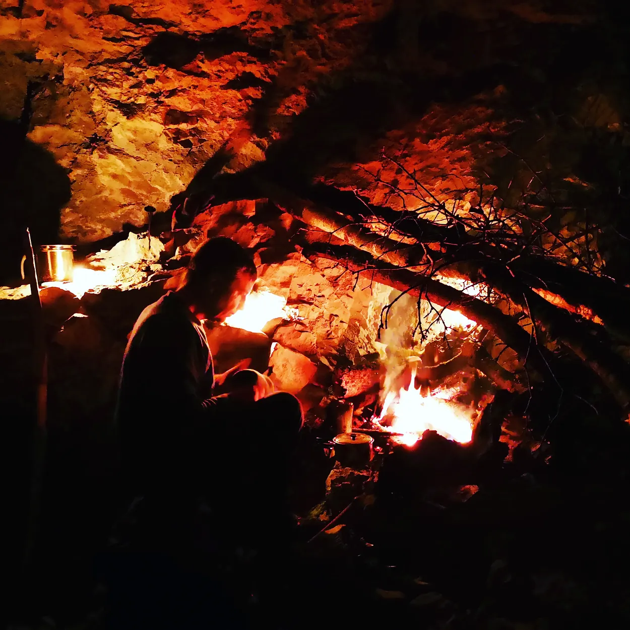 Udeleženec ob ognju v naravnem zavetju
